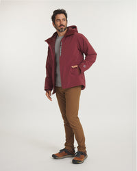 Three-quarter view of Men’s Apu Parka in burgundy showing insulated hood, zippered chest pocket, and relaxed fit on a plain light studio background