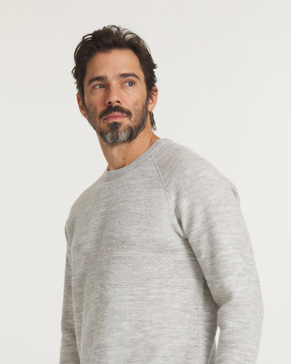 Man wearing a  Light Grey sweater against a plain background