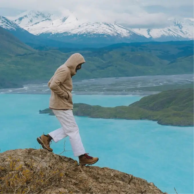 A man wearing a Timber Breathe Full Zip walking in front of a mineral blue lake