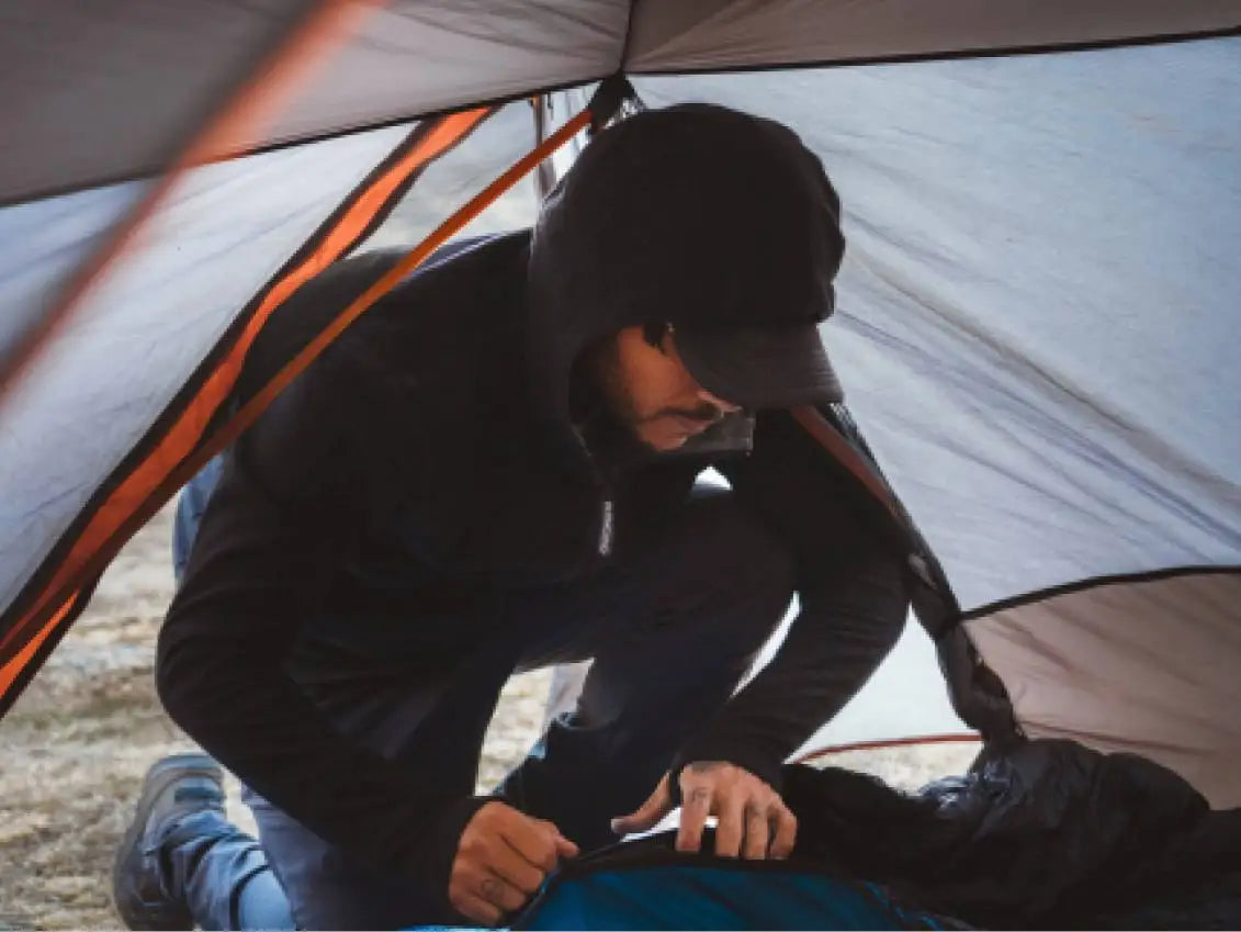 A man wearing a black breathe Full Zip in a tent