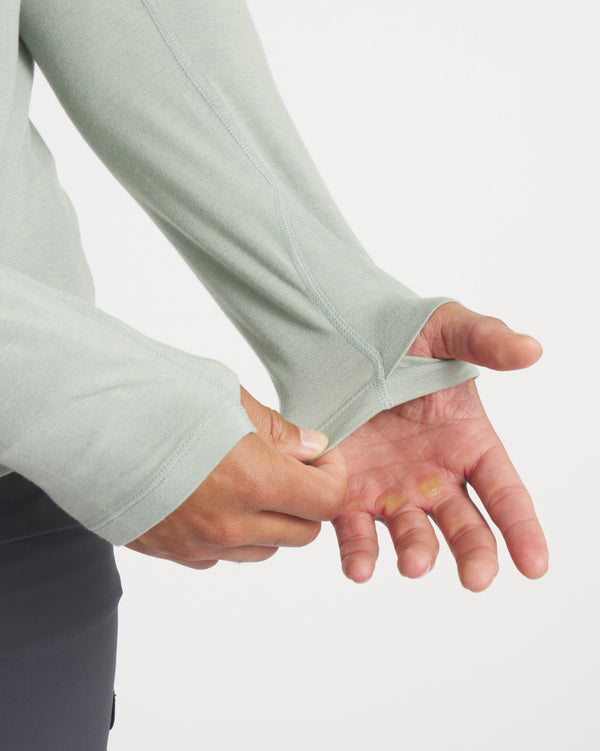 Hands Through Thumbholes of Sol Lightweight Alpaca Sun Hoodie in Lichen / Light Green – PAKA Apparel