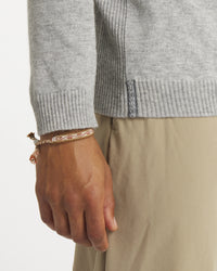 Close-up side view of Men’s Ultralight 1.0 crew in heather grey showing ribbed cuff, hem and woven side tag on model