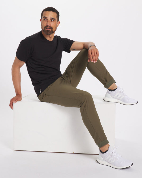 Model Sitting on White Block Wearing Sustainable Alpaca Blend Men's T-Shirt in Black – PAKA Apparel