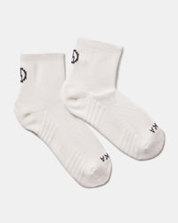 Top-down view of Trail 1/4 Crew socks showcasing ankle height, ribbed arch support, and PAKA logo on light gray background