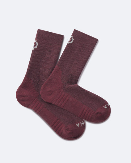 Flat lay of Trail 3/4 Crew Socks in burgundy showing ribbed arch, cushioned sole, and PAKA logo on toe