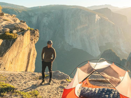 A man wearing The Vida Hoodie. He's camping in a canyon