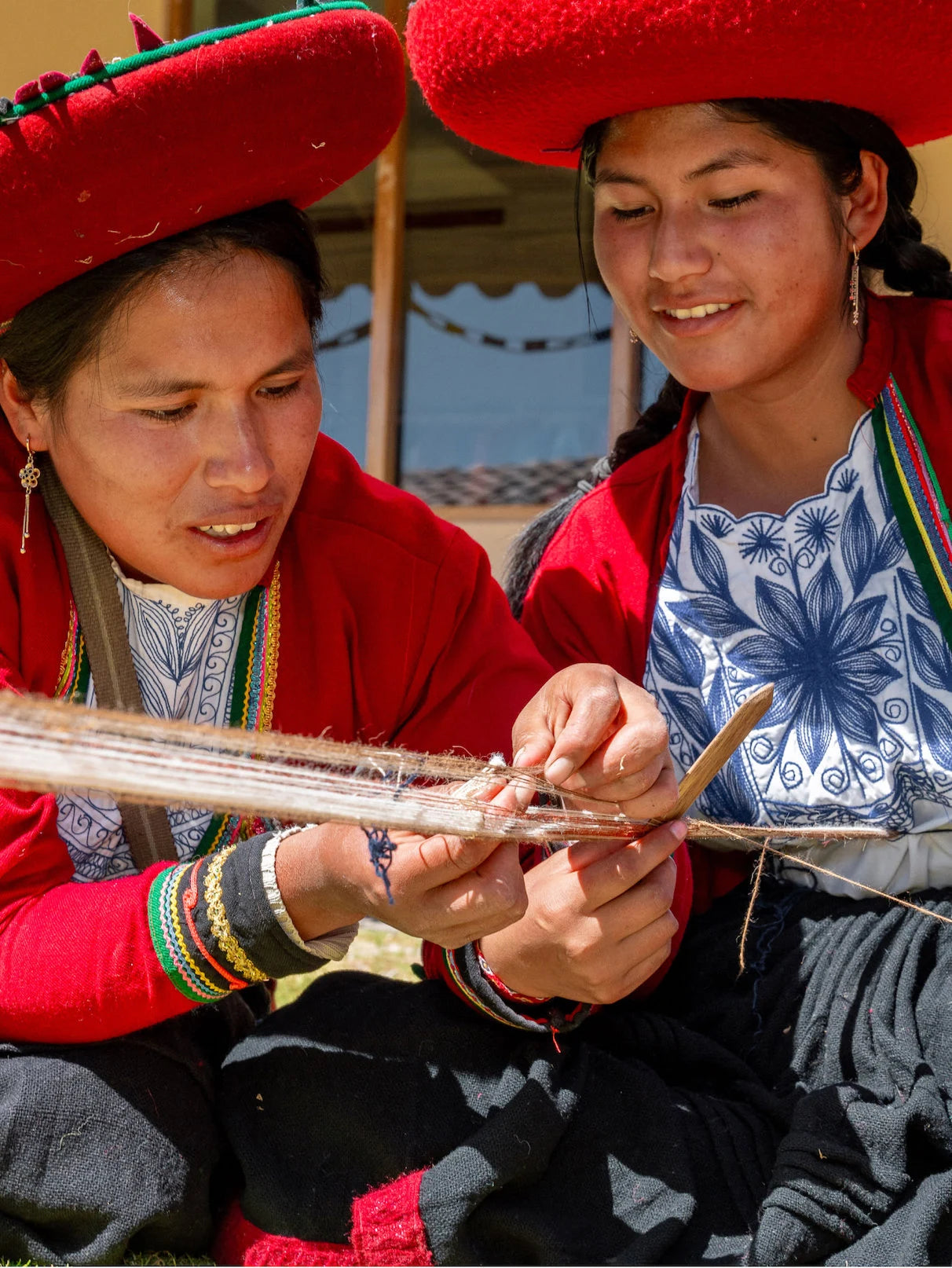 Two quechua women weaving a bracelet