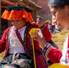Two Quechua women working with colorful alpaca fiber