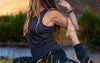 A woman wearing our alpaca Racer tank doing some yoga poses 