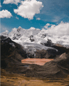 Red lake at the base of a snowy Peruvian mountain 
