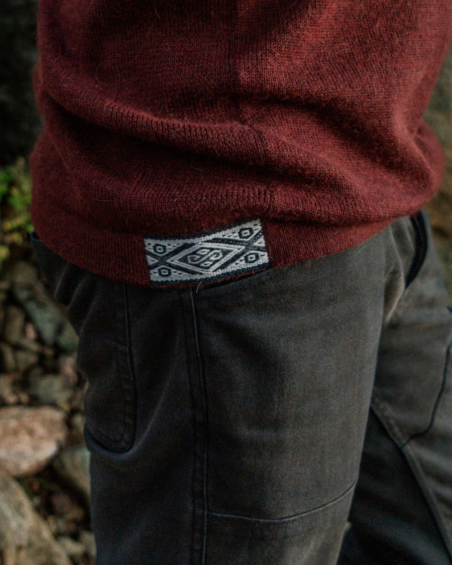 Close-up of PAKA's Burgundy Hoodie with the Inca ID worn by a person outdoors