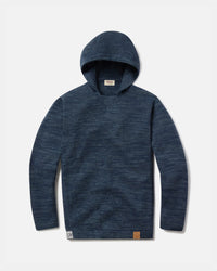 Flat lay of The Hoodie alpaca hoodie in navy showing hood, sleeves, knit texture, and hem logo patch on light gray background