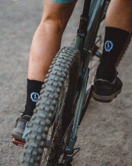 Black Alpaca Trail Crew Socks on Man Mountain Biking on Trail – PAKA Apparel