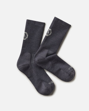 Top-down view of Trail Crew Socks showcasing charcoal blue color, crew height, cushioned footbed and PAKA logo on white background