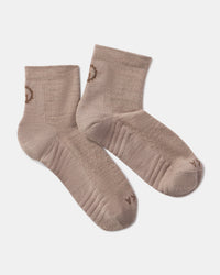 top view of Trail 1/4 Crew socks in taupe showing cushioned sole, ribbed cuff and small PAKA logo on white background