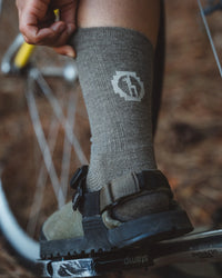 Forage / Dark Grey Moisture Wicking Alpaca Wool Crew Socks on Leg of a Biker – PAKA Apparel