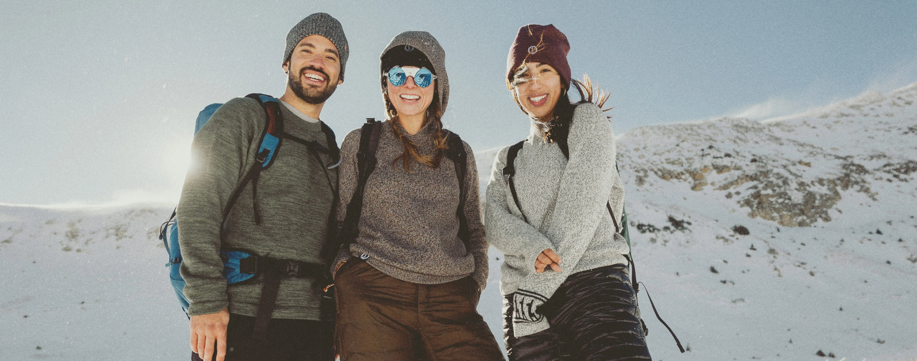 Three people posing for a photo in a snowy landscape
