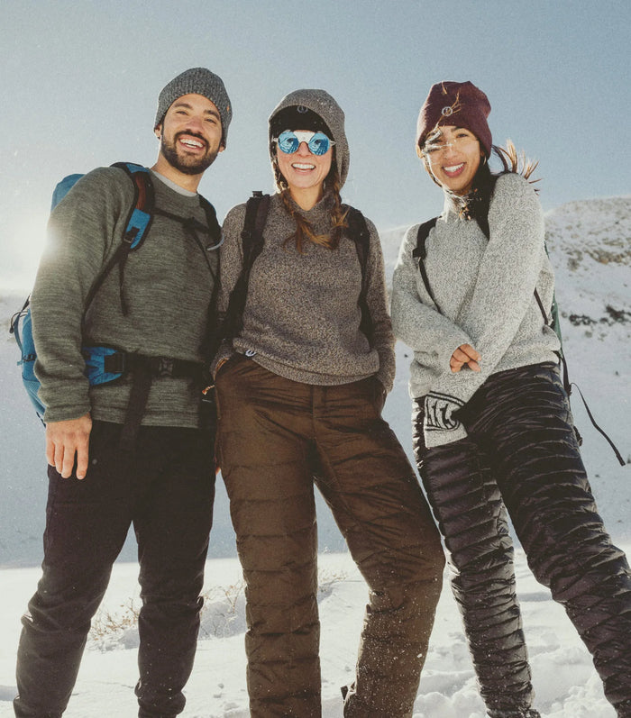 Three people posing together in a snowy landscape