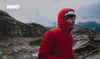 A man wearing a red Pakafill puffer jacket and a helmet in the Andes mountains