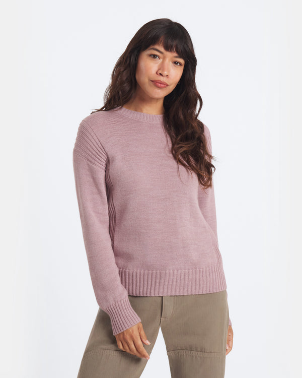 Woman wearing a pink sweater on a white background