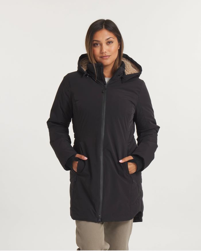 Woman wearing a black coat with a hood on a white background