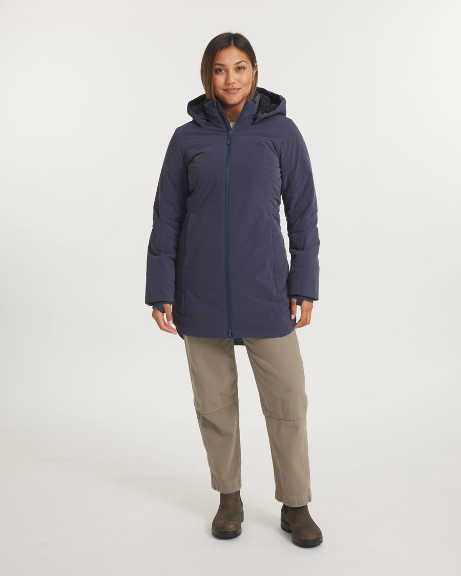 Woman wearing a navy blue coat on a white background