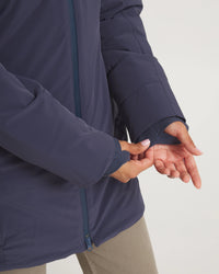 Person wearing a navy blue jacket with a close-up of the sleeve and hand.