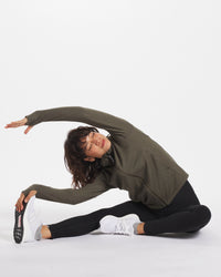 Woman Doing Yoga Pose Wearing a Green Breathe Full-Zip Alpaca Wool Hoodie for Activewear - PAKA Apparel