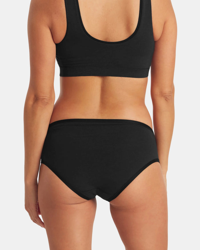 Back view of Women’s Essential Mid-Rise Brief showing mid-rise coverage, elastic waistband, black alpaca-blend fabric on light gray background