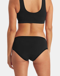 Back view of Women’s Essential Mid-Rise Brief showing mid-rise coverage, elastic waistband, black alpaca-blend fabric on light gray background