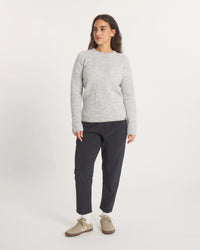 Woman wearing the Women's Mountain Crew Sweater in Light Grey  and black pants on a white background
