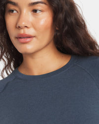 Front close-up of Women’s Sol Crew long-sleeve sun shirt in navy showing crew neck and raglan seam on model, white background