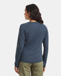 Back view of Women’s Sol Crew alpaca long sleeve sun protection shirt in navy showing raglan sleeve seams and slim fit on model against light gray background