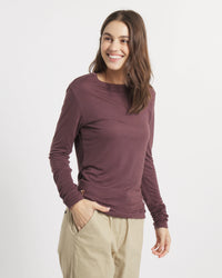 Three-quarter view of Women’s Aire Long Sleeve shirt in fig showing slim fit on model against white background