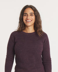 Woman wearing the Women's Mountain Crew sweater in Eggplant against a plain background