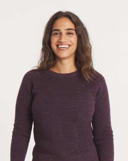 Woman wearing the Women's Mountain Crew sweater in Eggplant against a plain background