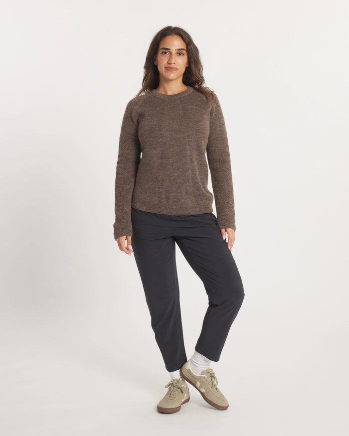Person wearing a Women's Mountain Crew sweater in Wood and black pants on a white background