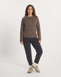 Person wearing a Women's Mountain Crew sweater in Wood and black pants on a white background