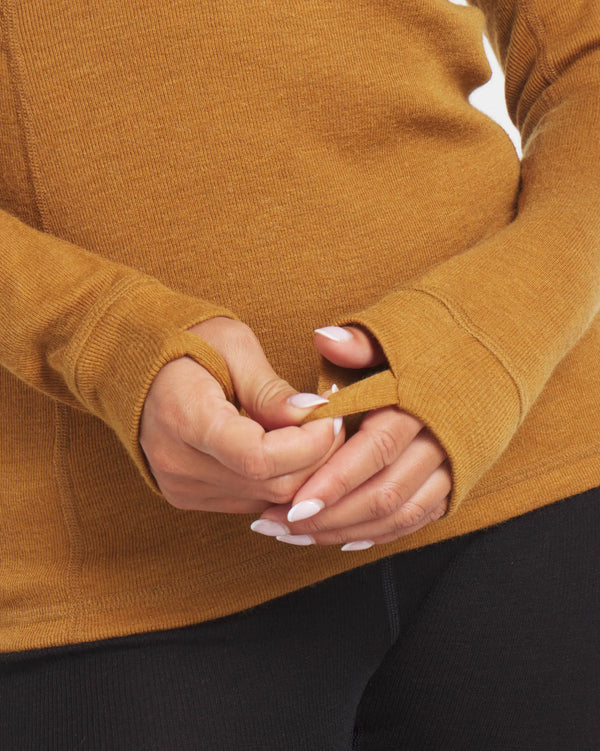 Close-Up of Woman's Hands Together Through Thumbholes of Golden Brown Alpaca Wool Thermal Long Underwear Top – PAKA Apparel