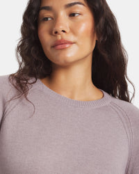 Woman wearing a light purple sweater against a plain background