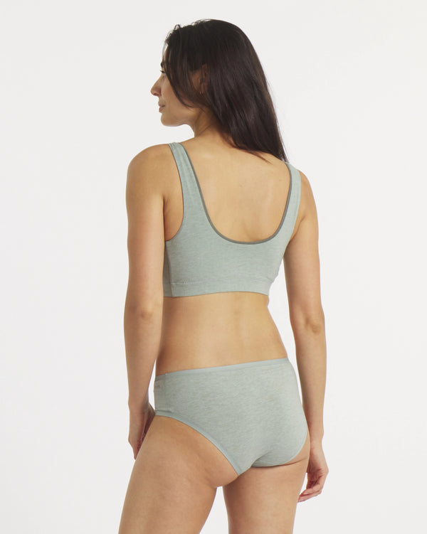 Woman wearing a green bikini set on a white background