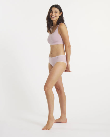 Woman wearing a light pink bikini set on a white background