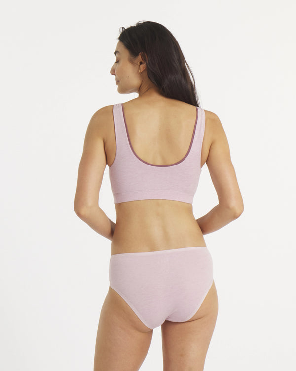 Woman wearing a light pink bikini set on a white background