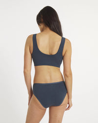 Woman wearing a dark blue bikini set on a white background