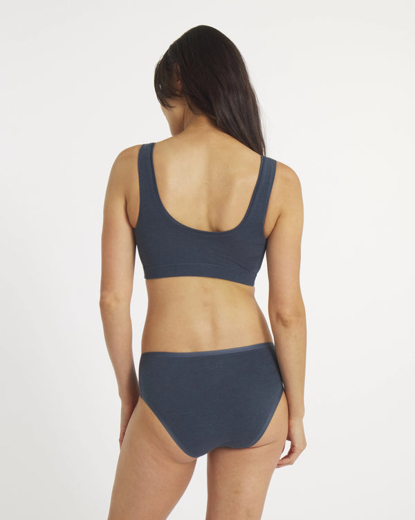 Woman wearing a dark blue bikini set on a white background