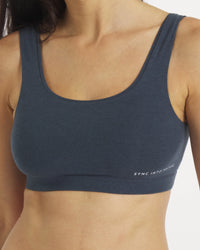 Navy blue sports bra with 'SYNC INTO ACTION' text on a neutral background