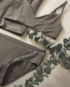 Women's Forage Triangle Bralette and Mid-Rise Brief with 'SYNC INTO NATURE' branding on a light background with eucalyptus leaves.