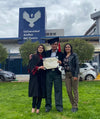 Paka scholar Thilcia holding her degree diploma with her family in front of the Universidad Andina del Cusco