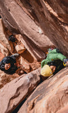 Two women climbing rocks in their Pakafill puffer jackets