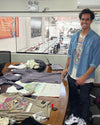 Neil Gayoso, peruvian designer smiling with the final designs of our Explore Peru shirts